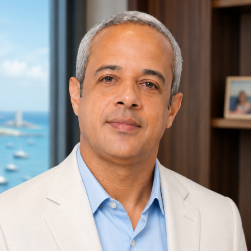 Glauco de Moraes da Silva, especialista em viagens para o Rio de Janeiro, em retrato profissional usando blazer esporte fino azul-marinho em escritório executivo.