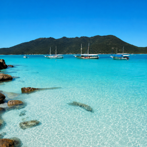 Praia de Arraial do Cabo no Rio de Janeiro com mar azul cristalino, areia branca e barcos na paisagem